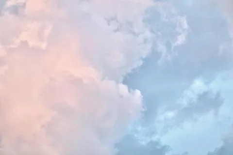 A serene sky scene featuring a patchwork of soft blue, pale pink, and grey .. Stock Photos