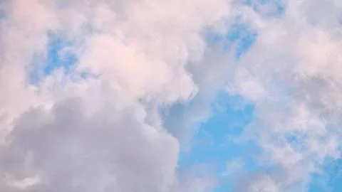 A serene sky scene featuring a patchwork of soft blue, pale pink, and grey .. Stock Photos