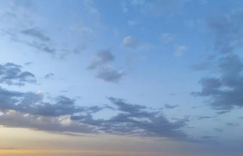 Serene sky at sunset featuring soft, fluffy clouds illuminated by warm colors, Stock Photos