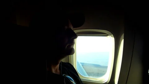 Serene Sky Vibes: Middle-Aged Male Enjoying In-Flight Wi-Fi Music Stock Footage 235050565
