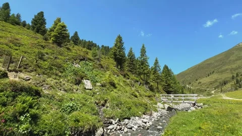 Serene Slow-Motion pan across Lush Green Hills and a Gentle Stream in the A.. Stock Footage 332713676