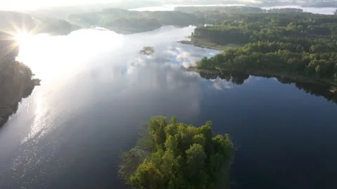 Serene small island surrounded by calm lake waters in dense forest Stock Footage 345593861