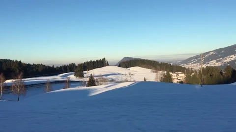 A serene snowcovered landscape featuring beautiful hills and a cozy cabin Stock Footage 307351094