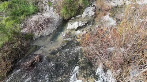 A Serene Stream Flowing Gently Over Rocky Terrain in the Heart of Natures Beauty Stock Footage 300474356