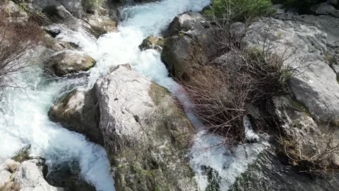 A Serene Stream Flowing Gently Over Rocky Terrain in the Heart of Natures Beauty Stock Footage 300474393