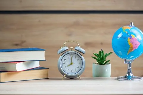 A serene study space featuring a stylish clock, neatly arranged books, and .. Stock Photos
