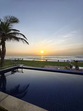 Serene sunrise over an infinity pool overlooking the scenic East Coast Road.. Stock Photos