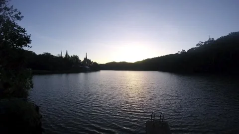 Serene sunrise time lapse over a peaceful lake with gentle ripples Stock Footage 344976488