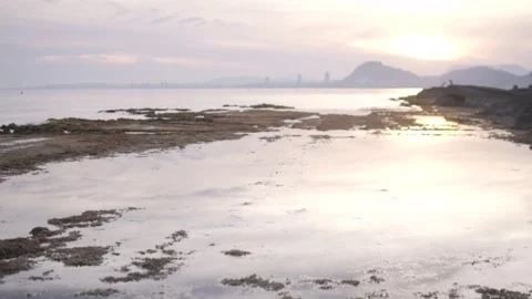 A serene sunset casting a golden glow over the calm waters, with fluffy clouds Stock Footage 269508065