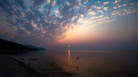 A Serene Sunset Gracefully Setting Over the Tranquil and Peaceful Waters of Stock Photos