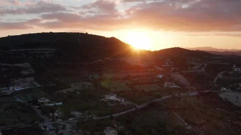 A serene sunset landscape with red-tiled roof village nestled in lush greenery Stock Footage 309463832