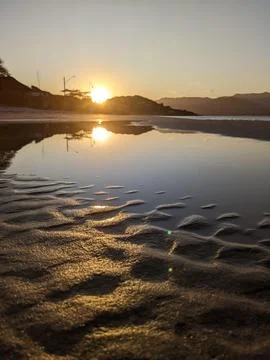 Serene sunset over beach reflection Stock Photos