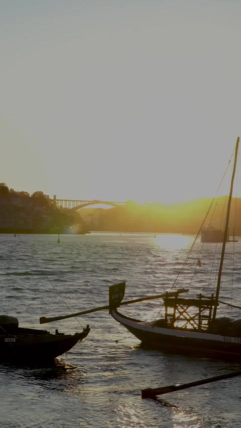 A serene sunset over water with two docked boats, showcasing nature Stock Footage 280605449