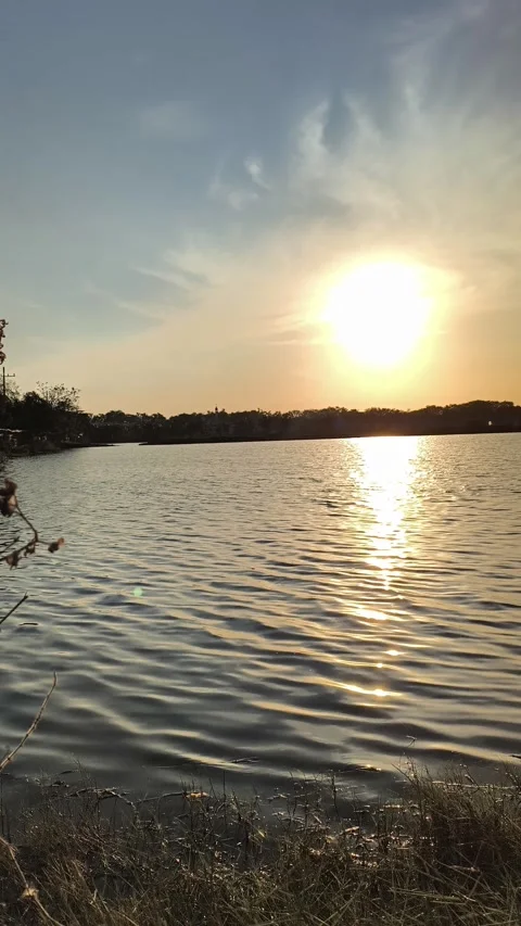Serene Sunset Reflection on Calm Lake Water During Golden Hour Video stock 340489993