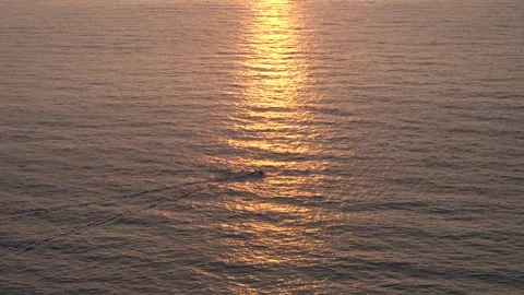 Serene Sunset Reflection Over Calm Water with a Small Boat Silhouette Stock Footage 301166528