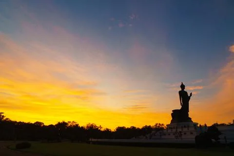 Serene sunset view featuring large Buddha statue silhouetted against vibran.. Stock Photos