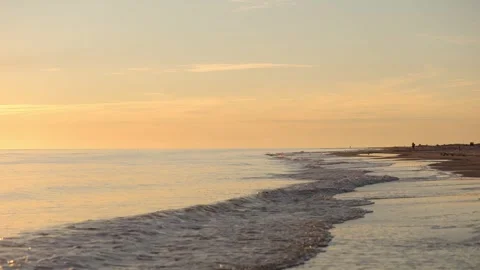 Serene sunset view at a tranquil beach with gentle waves rolling in during the Stock Footage 287787482
