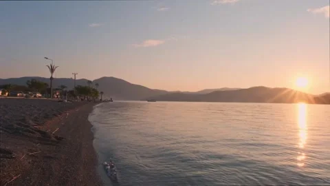 Serene Sunset: Waves Caressing Çalış Beach Coast Stock Footage 240767657