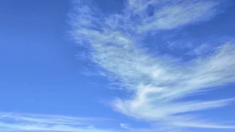 Serene timelapse of slow-moving clouds drifting across a clear blue sky Stock Footage 316335997