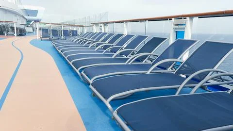 A serene view of blue deck chairs perfectly arranged in neat rows on a luxu.. Foto stock