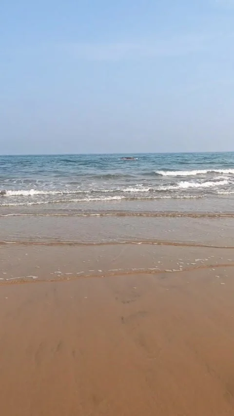 Serene view of a calm sandy beach with gentle waves rolling onto the shore under Vídeos de archivo 334164007