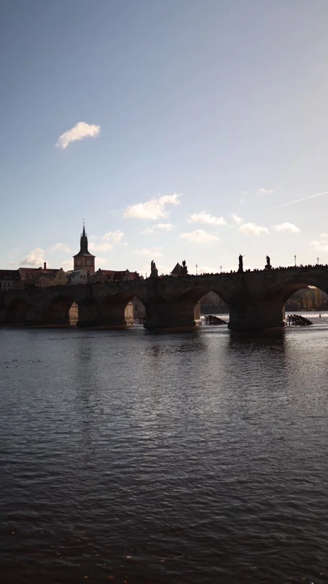 A serene view of Charles Bridge in Prague, with its historic statues and gothic  Stock Footage 293466039