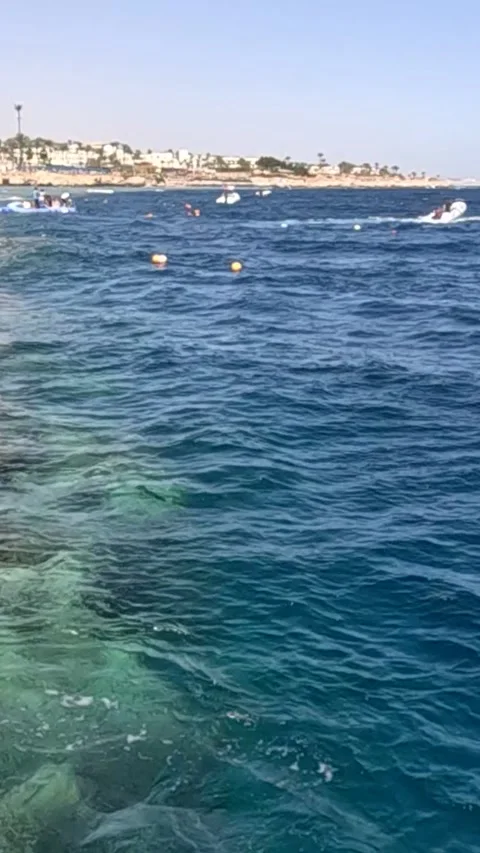 A Serene View of Clear Blue Waters Amidst Boats and Coastal Scenery, Capturing Video stock 330096212