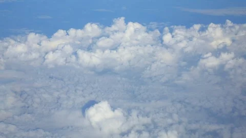 A serene view of fluffy clouds as seen from an airplane, with clear blue sk.. Stock Footage 291170495