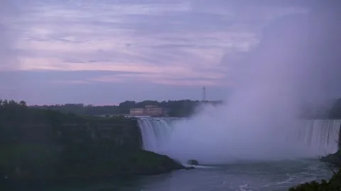 Serene view of Niagara Falls enveloped in mist at dusk, set against tranquil Stockbeeldmateriaal 291509073