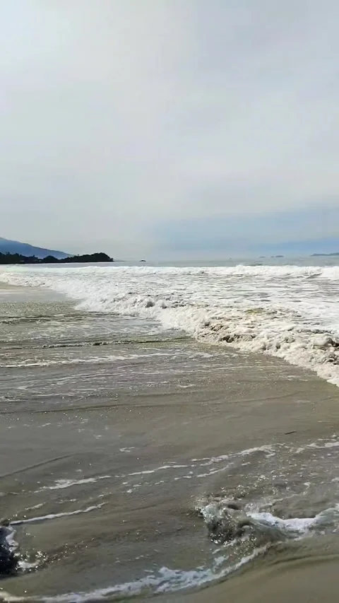 Serene view of ocean waves gently crashing onto a sandy beach Stock Footage 321014278