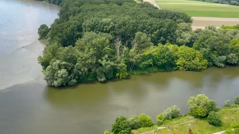 A serene view of a river surrounded by lush green forests and distant hills Stock Footage 297760352