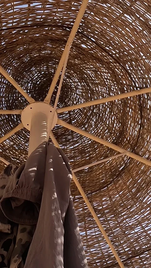 A Serene View from Under a Rustic Umbrella Showcasing Woven Textures and Video stock 331279419