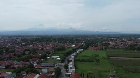 Serene Village with Lush Rice Fields and Mountain View Covered by Clouds Stock Footage 259554359