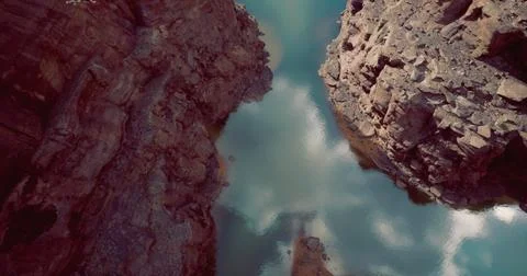 Serene water reflection between rocky cliffs in a remote canyon location Stock Illustration