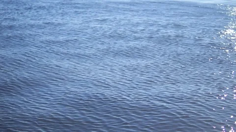 A Serene Water Surface with Gentle Ripples Creatively Reflecting the Warm Stock Footage 289437948