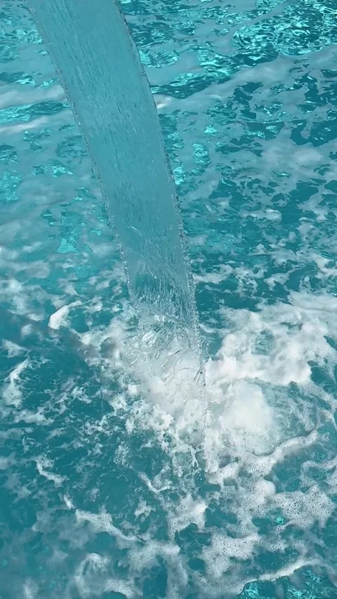 A serene waterfall cascades into a tranquil pool, creating a soothing ambianc Stock Footage 303358309