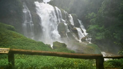 Serene Waterfall Cascading Down Lush Green Cliffs in Chiang Mai Stock Footage 315491428