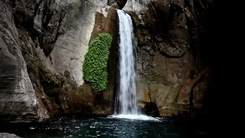 Serene Waterfall Cascading Down Rocky Gorge, Lush Greenery Stock Footage 301088381