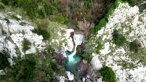 A Serene Waterfall Gracefully Cascades Down Over Rocks, Completely Surrounded by Stock Footage 300473743