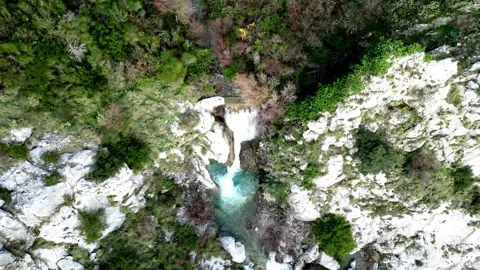 A Serene Waterfall Gracefully Cascades Down Over Rocks, Completely Surrounded by Stock Footage 300473792