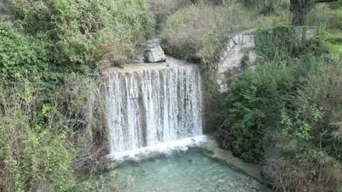 A Serene Waterfall Gracefully Cascades Down Over Rocks, Completely Surrounded by Stock Footage 300473966