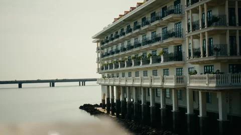 Serene waterfront hotel with multiple balconies Stock Footage 343594784