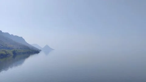 Serene Waters Reflecting Distant Mountains Stock Footage 327913449