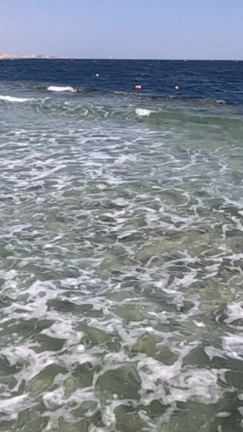 Serene Waves Gently Lapping on a Crystal-Clear Shoreline, Capturing the Tranquil 库存影片 330094823