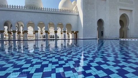 A serene wide shot of the Sheikh Zayed Grand Mosque’s blue-tiled reflective 動画素材 321807747