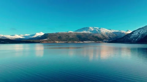 Serene Winter Landscape, Snow Capped Mountains and Reflective Lake in Norway Stock Footage 315736730