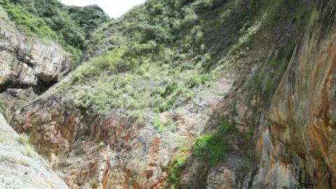 Serene yet dramatic aerial of orange canyon in jungle, blue river rapids Stock Footage 324900839