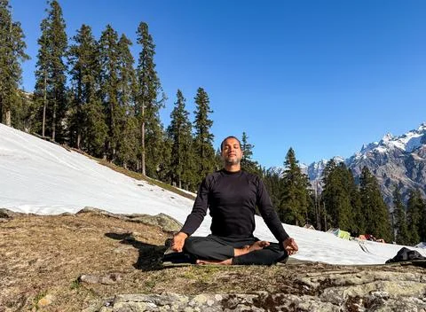 Serene yoga practice in cold environment with natural scenic backdrop Stockfoto's