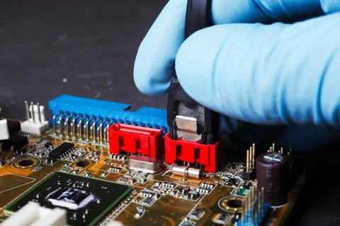 Serial ata connection of cable with computer motherboard, hand of engineer wi Stock Photos