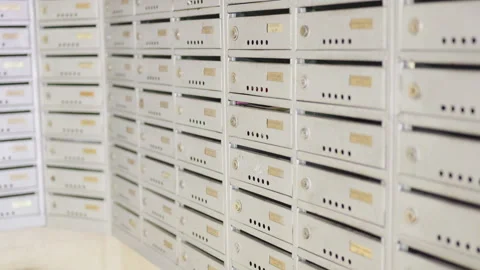 Series of close-up frames showing a row of silver mailboxes with gold nameplates Stock Footage 340554083